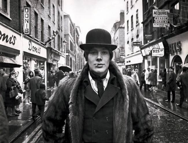 Fashionable male wearing a bowler hat and fur coat in Carnaby Street dandy, London anonymous