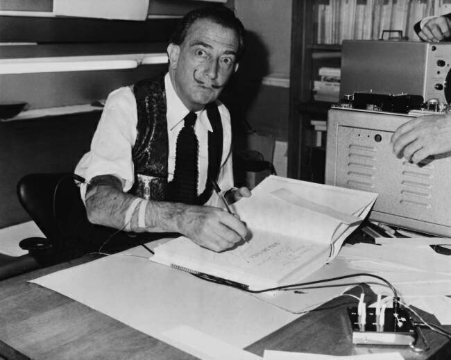 Salvador Dali signing his book Dali de Gala Keystone