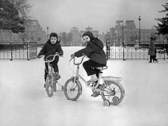 Hiver à Paris dans les années 60: Enfants sur des tricycles dans la neige dans le parc des Tuileries anonyme