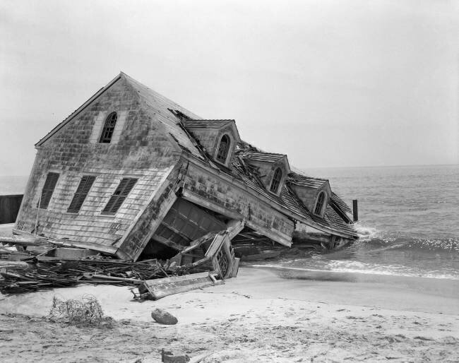 Une maison de bord de mer emportée dans l'océan détruit par une tempête anonyme