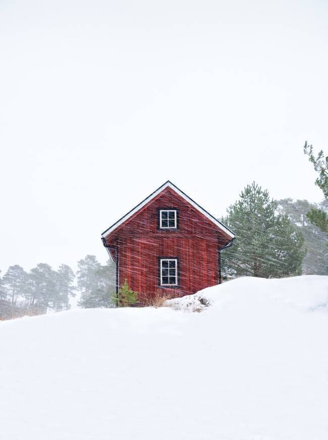 Old red house during snowstorm Christian Lindsten