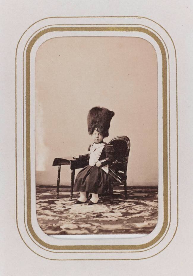 Portrait d'un enfant assis, coiffé d'une toque en fourrure. anonymous