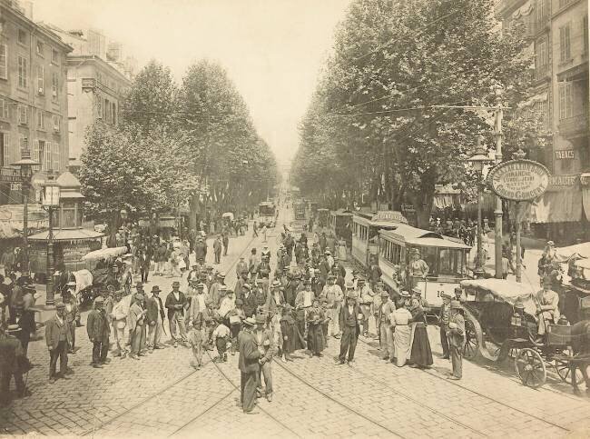 Boulevard parisien avec foule, voitures à cheval et tramway anonyme