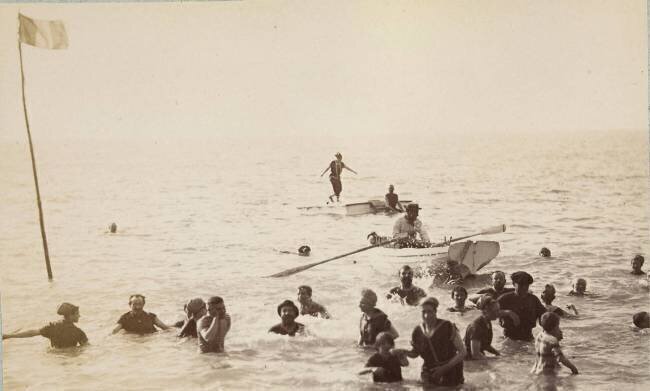 Groupe de baigneurs debout ou nageant dans la mer, et une barque Gustave Eiffel