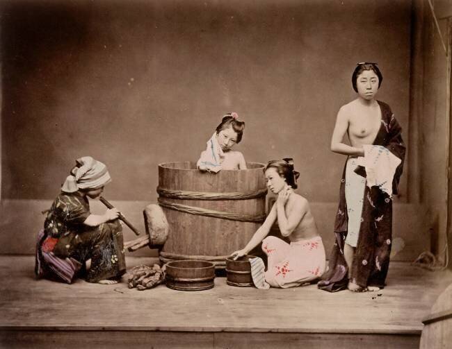 Scène de la vie japonaise, japonaises prenant leur bain, une domestique souffle pour activer le feu Felice Beato