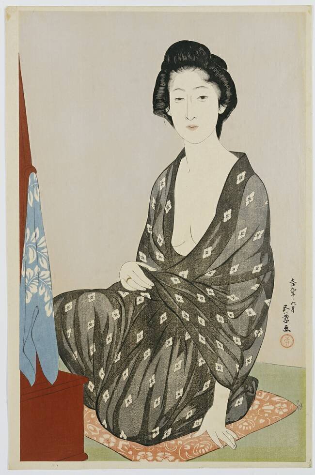 A beauty in a black kimono with white hanabishi patterns, seated before a mirror, 1920 Goyo Hashigushi