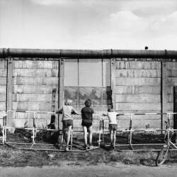 Des enfants regardent le mur de Berlin (Gert Schütz) - Muzeo.com