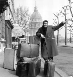 Jean-Claude Pascal attend un taxi à Paris avant de partir en Espagne, 18 mars 1959 (Rue des Archives) - Muzeo.com