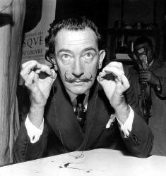 Le peintre Salvador Dali présentant une œuvre d'art qui sera détruite par le feu des mousquets le 16 novembre 1956. (Rue des Archives) - Muzeo.com