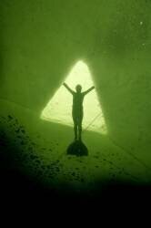 Plongeuse en apnée sous la banquise de la Mer Blanche ; Elle s'accroche aux bords du trou d'entrée. (Dan Burton) - Muzeo.com