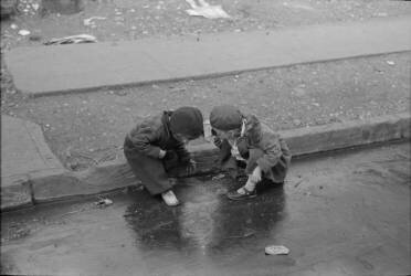 Enfants jouant dans le caniveau à New York (Dorothea Lange) - Muzeo.com