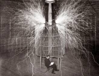 Nikola Tesla sitting in his Colorado Springs laboratory with his “Magnifying Transmitter” (anonymous) - Muzeo.com