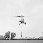 La trapéziste Andrée Jean lors d'une démonstration d'exercices de trapèze aérien en hélicoptère au Polo de Bagatelle, Paris, le 16 juin 1951 (Rue des Archives) - Muzeo.com