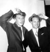 Le chanteur Johnny Hallyday avec sa cousine par -mariage Lee Ketcham présentant le chapeau du nouveau modèle tyrolien 27 septembre (Rue des Archives) - Muzeo.com