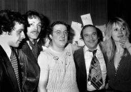 L'humoriste français Coluche avec ses amis dans les coulisses Février Francis Perrin Patrick Dewaere Jean Marc Thibault et Miou-Miou (Rue des Archives) - Muzeo.com