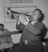 Louis Armstrong jouant de la trompette arrivant à l'aéroport d'Orly (Rue des Archives) - Muzeo.com