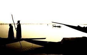 IN*Mali, Mopti, pirogues sur le fleuve Niger, silhouettes de deux piroguiers (Bernard Foubert) - Muzeo.com