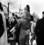 Des soldats des forces alliées soulèvent une jeune femme (Rue des Archives) - Muzeo.com