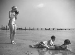 Woman in a bathing costume filming children by the sea (anonymous) - Muzeo.com