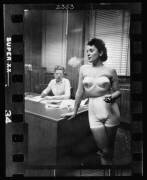 Woman model, standing in an office, smoking while modeling undergarments (Stanley Kubrick) - Muzeo.com